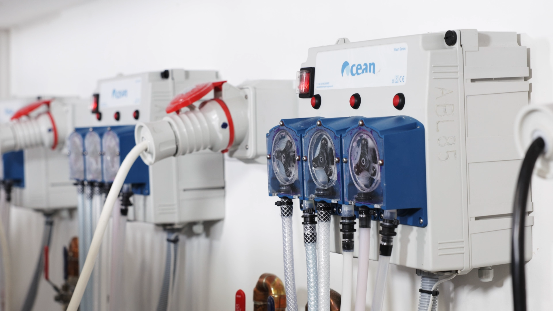 An auto dose system on the wall. A great Eco-Friendly Laundry Solutions for Care Homes. It's blue and grey with dials for dispensing laundry chemicals.