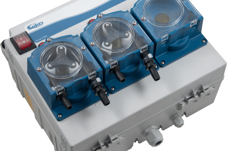 A three-chamber dosing pump system with clear lids and blue housings, featuring a red power switch on the upper left corner. These laundry auto Dosing systems help care homes stay compliant.
