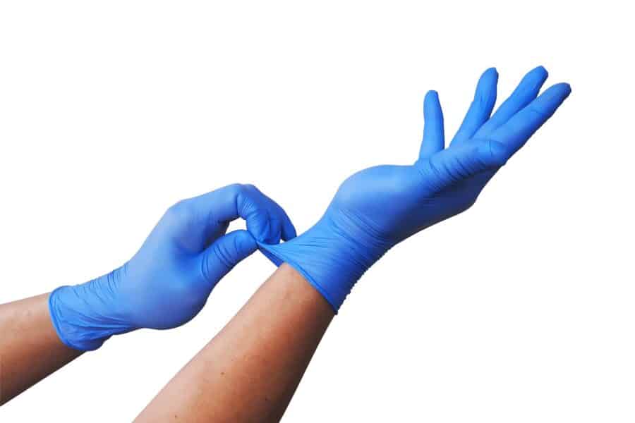 Hands wearing disposable blue nitrile gloves for comparison of vinyl vs nitrile