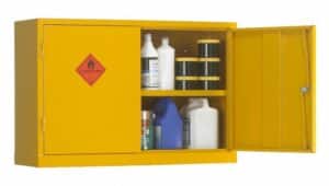 A yellow metal cabinet labeled "flammable liquid" contains bottles and cans on two shelves, with the right door open.