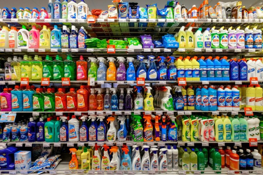Supermarket shelf stocked with a variety of general purpose and multipurpose cleaning spray bottles