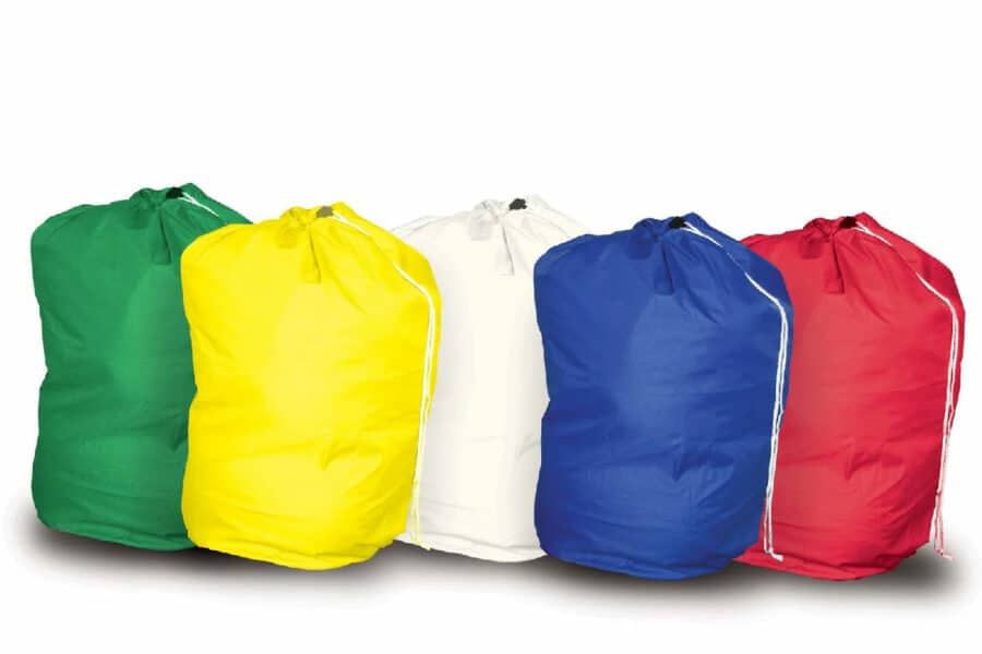 Colour-coded laundry bags for care home use, including red, blue, white, yellow, and green drawstring bags